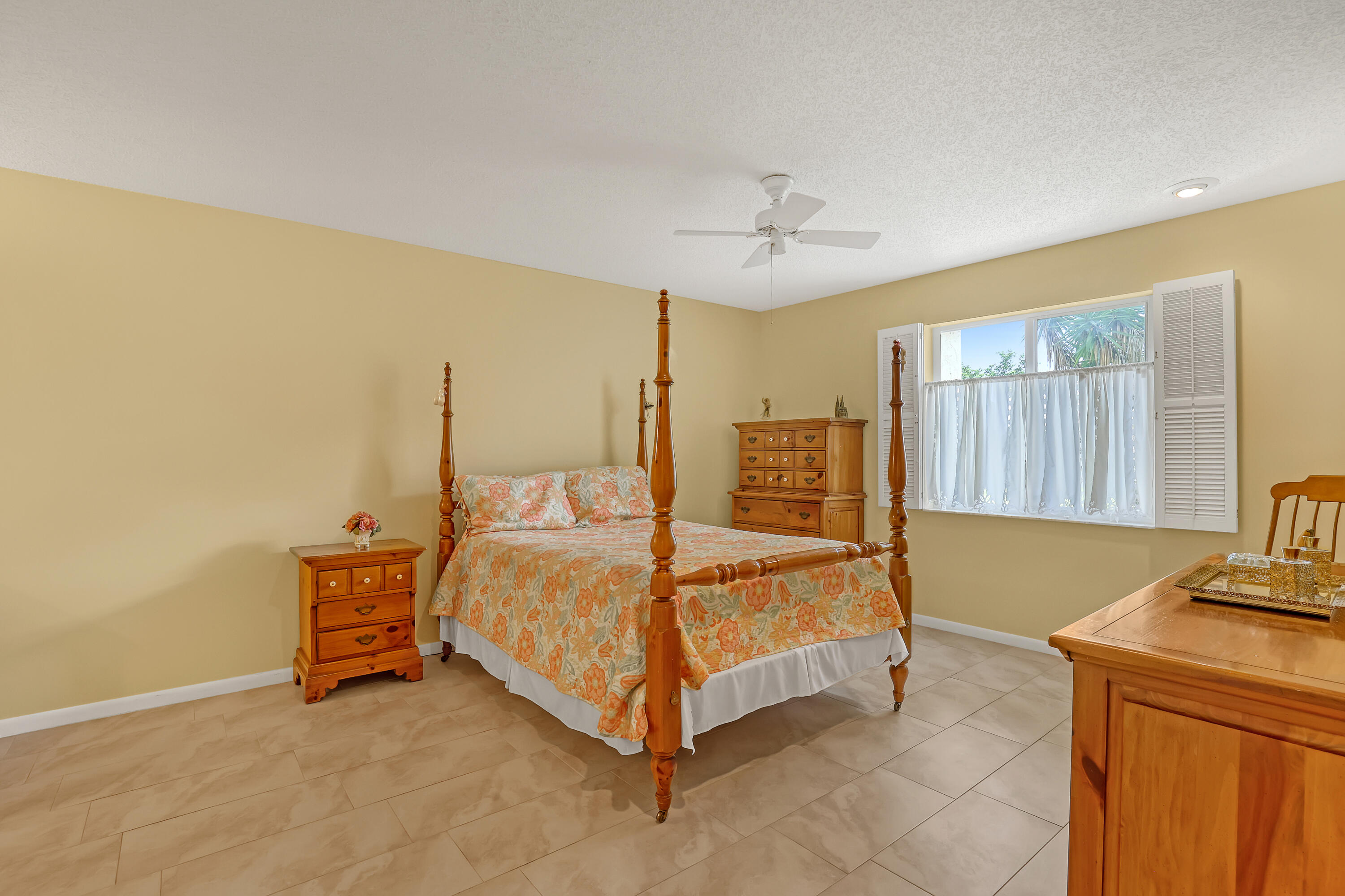1850 Northwest 18th Street, Unit 103 Delray Beach, FL 33445 - Photo 13 of 28 a bed room with a bed and a chandelier
