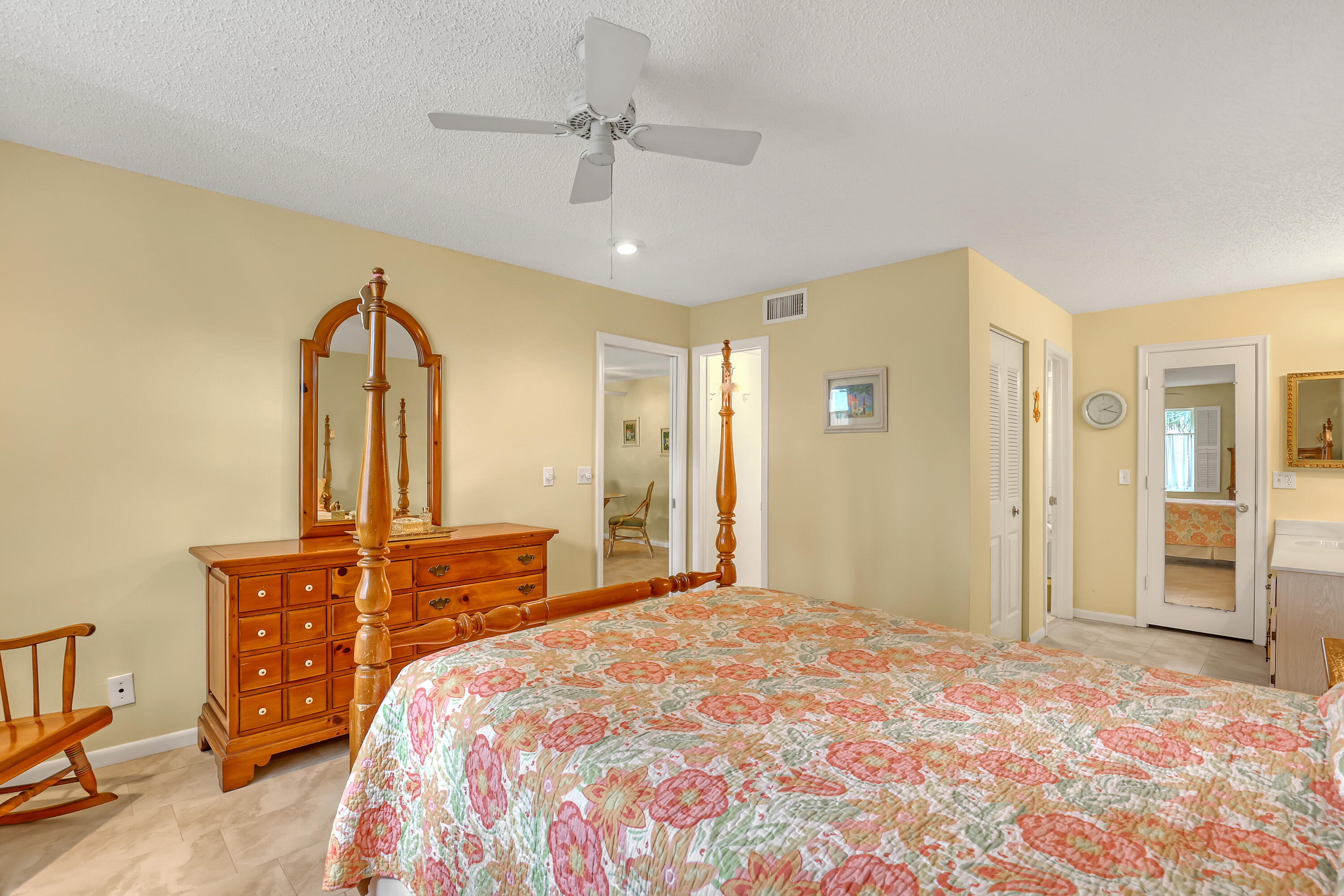 1850 Northwest 18th Street, Unit 103 Delray Beach, FL 33445 - Photo 14 of 28 a bedroom with a bed dresser and mirror