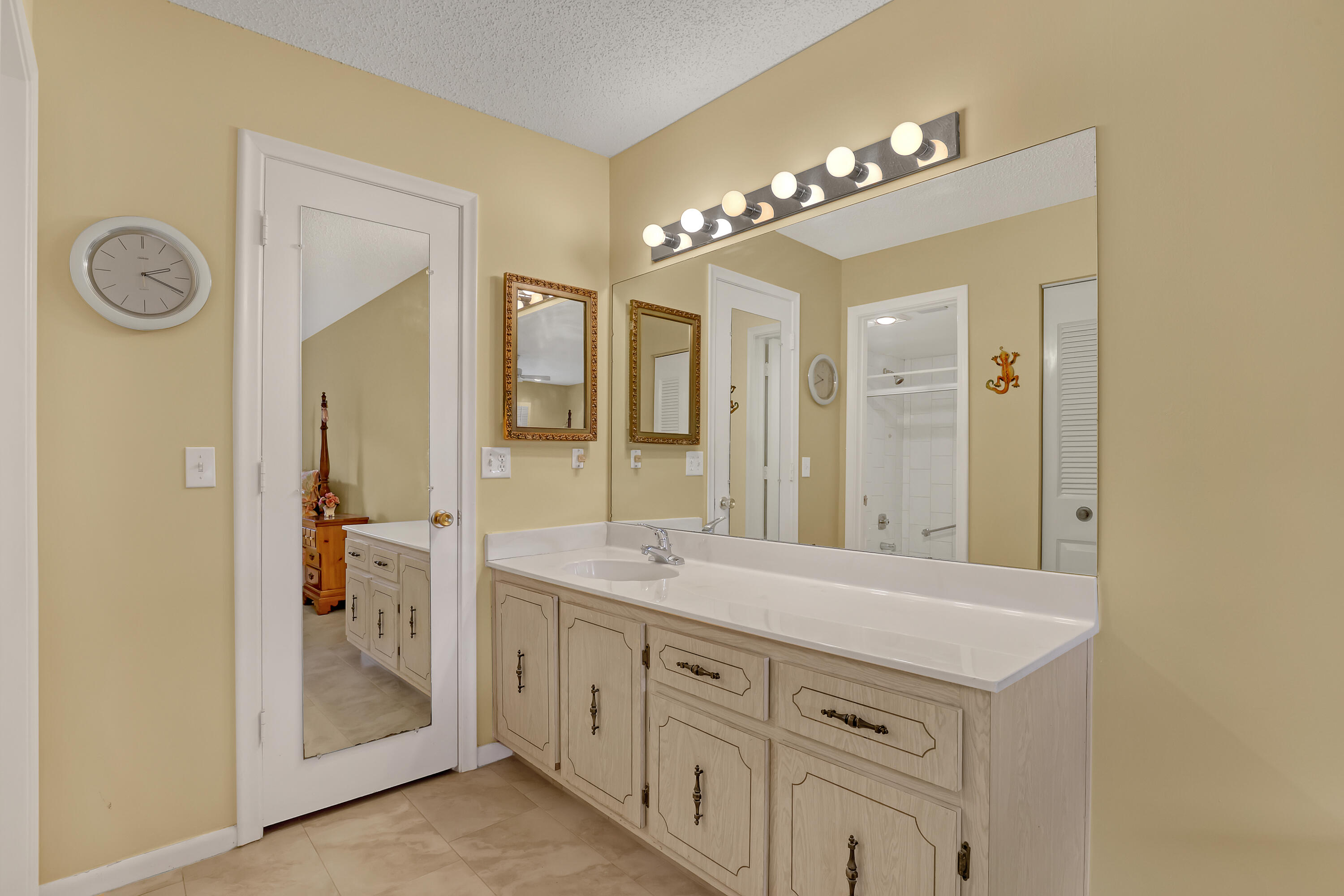 1850 Northwest 18th Street, Unit 103 Delray Beach, FL 33445 - Photo 17 of 28 a spacious bathroom with a granite countertop sink and a mirror