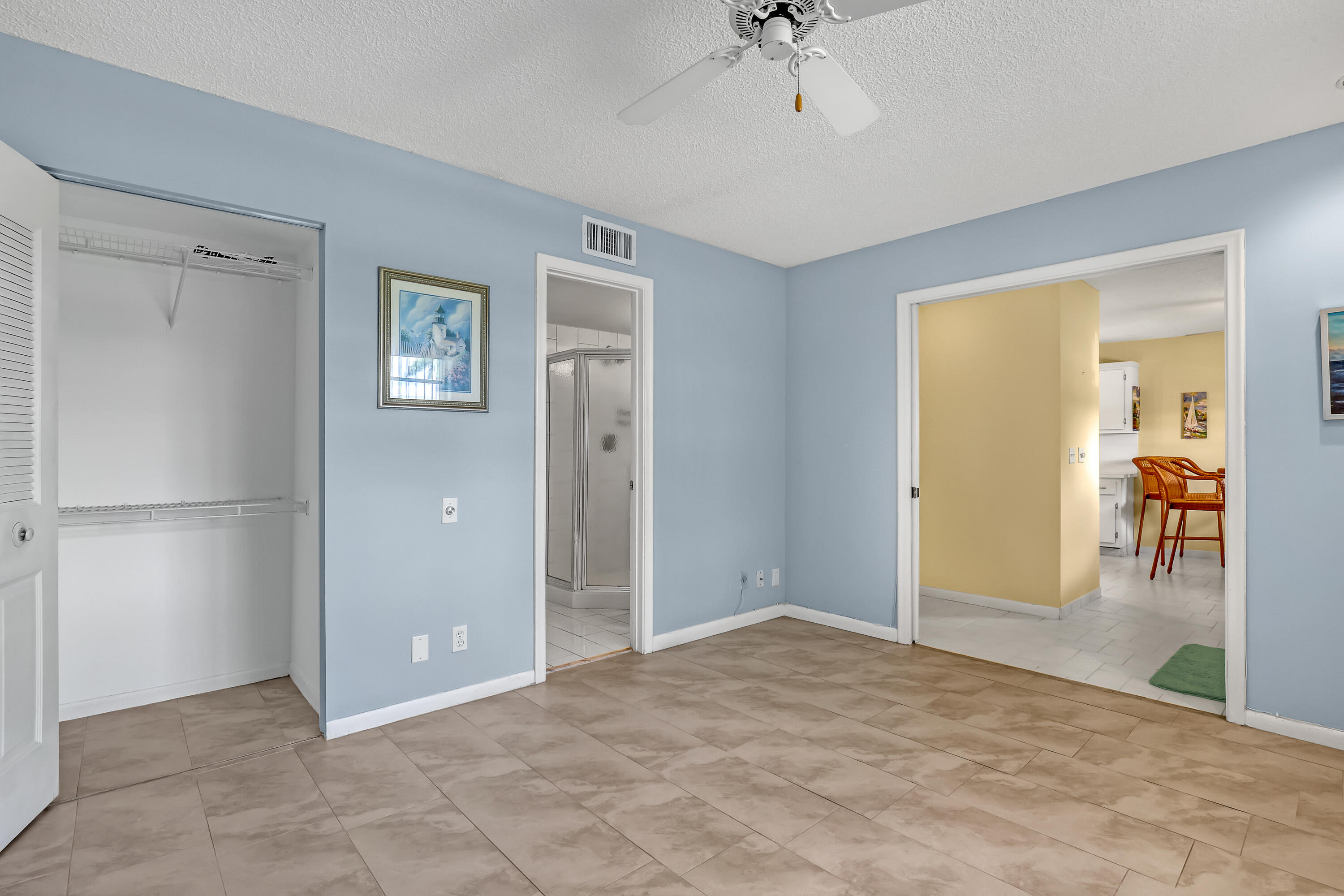 1850 Northwest 18th Street, Unit 103 Delray Beach, FL 33445 - Photo 20 of 28 a view of a room with wooden floor and ceiling fan