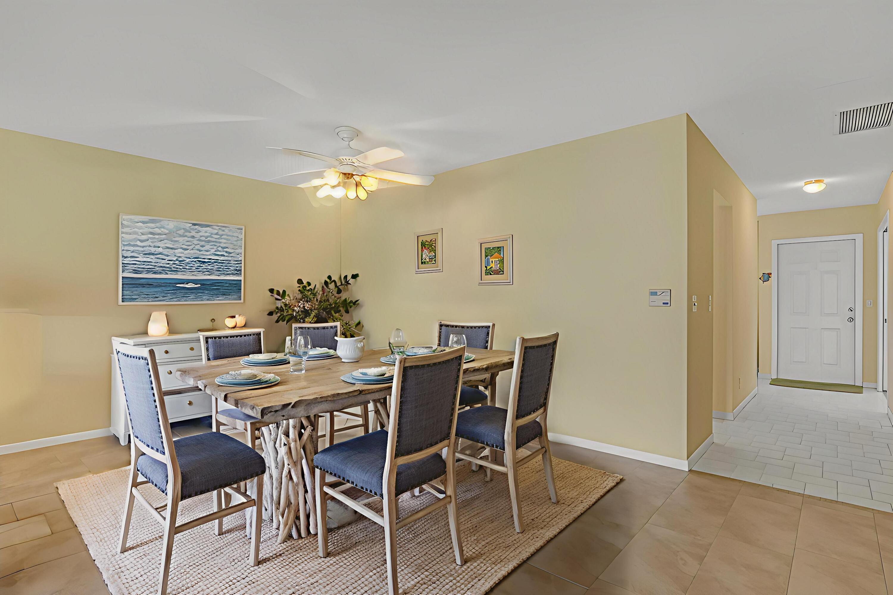 1850 Northwest 18th Street, Unit 103 Delray Beach, FL 33445 - Photo 2 of 28 a view of a dining room with furniture and chandelier