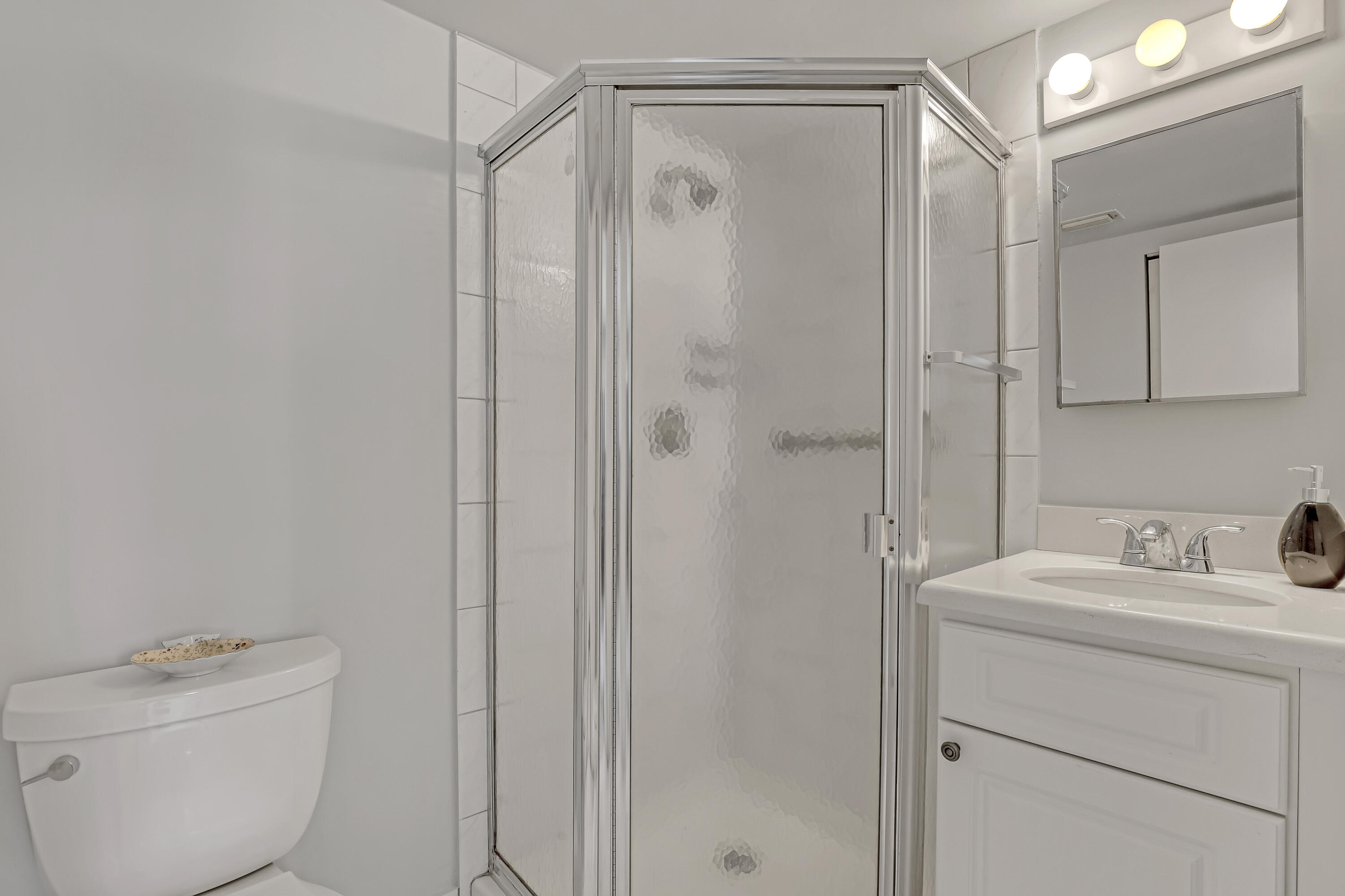 1850 Northwest 18th Street, Unit 103 Delray Beach, FL 33445 - Photo 22 of 28 a bathroom with a sink a toilet and shower