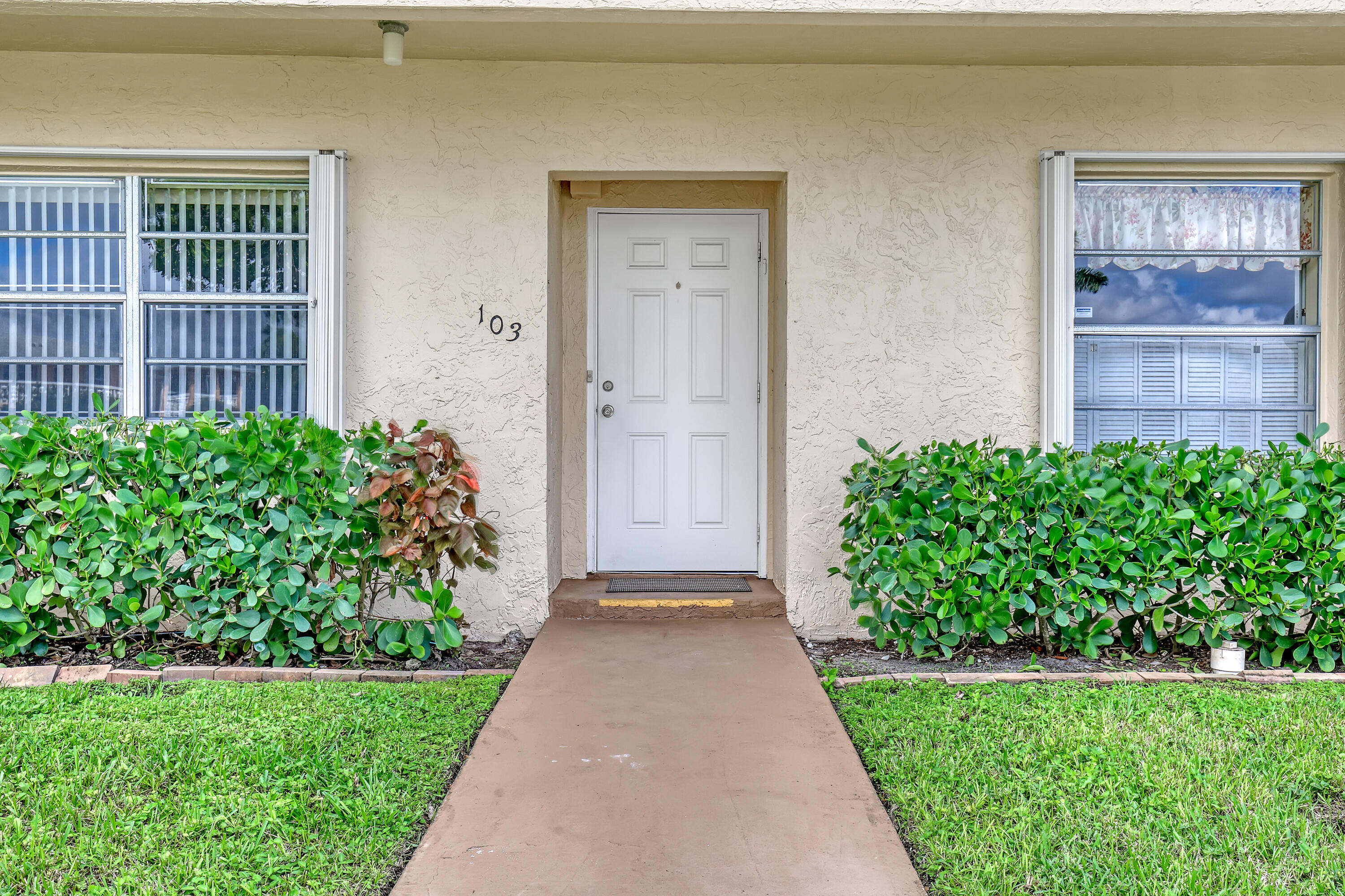1850 Northwest 18th Street, Unit 103 Delray Beach, FL 33445 - Photo 5 of 28 a view of a house with a yard and garden