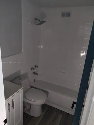 a white toilet sitting next to a bath tub