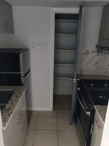 a kitchen with a refrigerator and a stove top oven