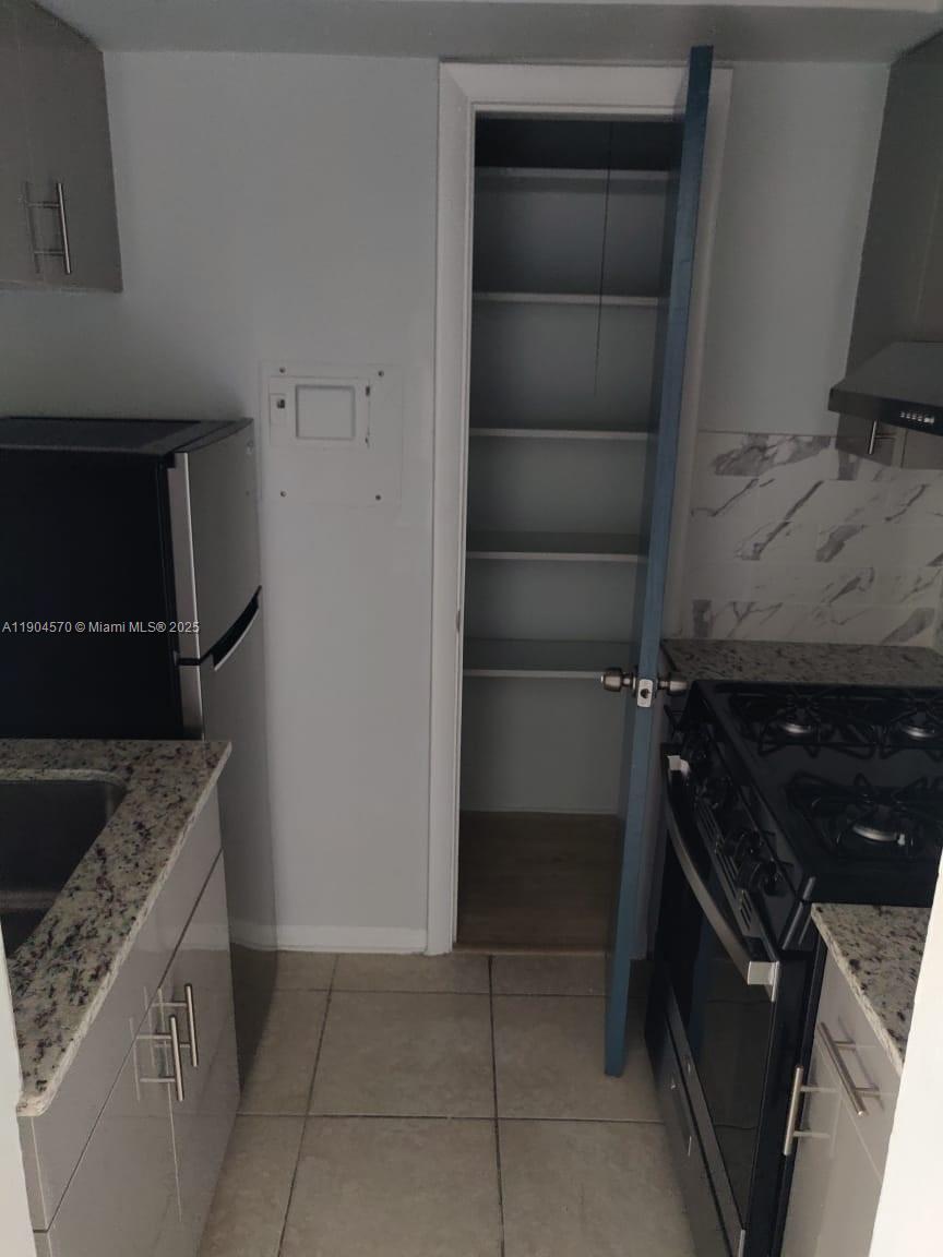 2300 Southwest 3rd Avenue, Unit 9 Miami, FL 33129 - Photo 5 of 13 a kitchen with a refrigerator and a stove top oven