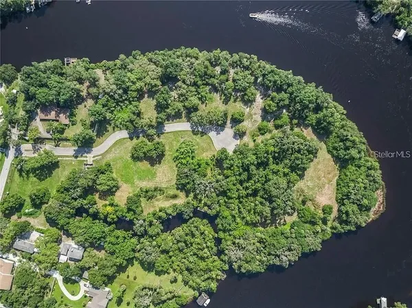 an aerial view of a house with a yard and lake view