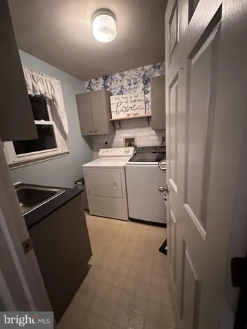 a utility room with cabinets washer and dryer