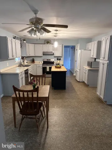 a kitchen with a table chairs refrigerator and microwave