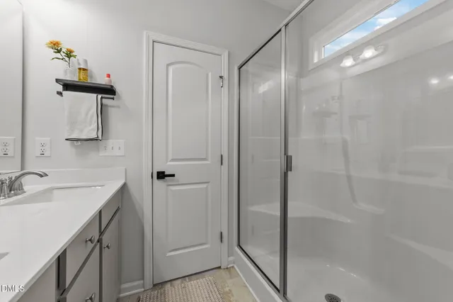 a bathroom with a shower sink and mirror