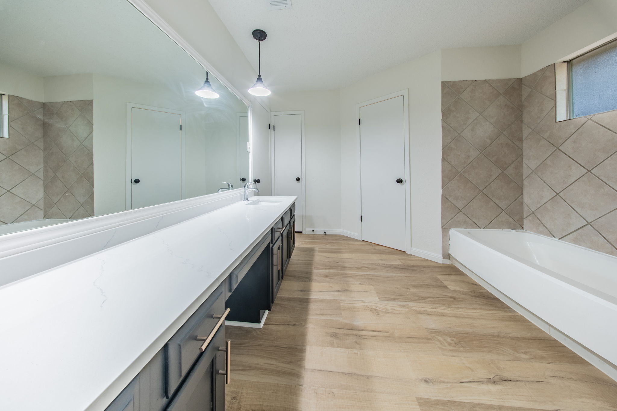 4504 Langtry Lane Austin, TX 78749 - Photo 14 of 24 Modern primary bathroom offers a double vanity, large mirror, and soaking tub.