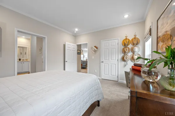 a spacious bedroom with a bed and wooden floor