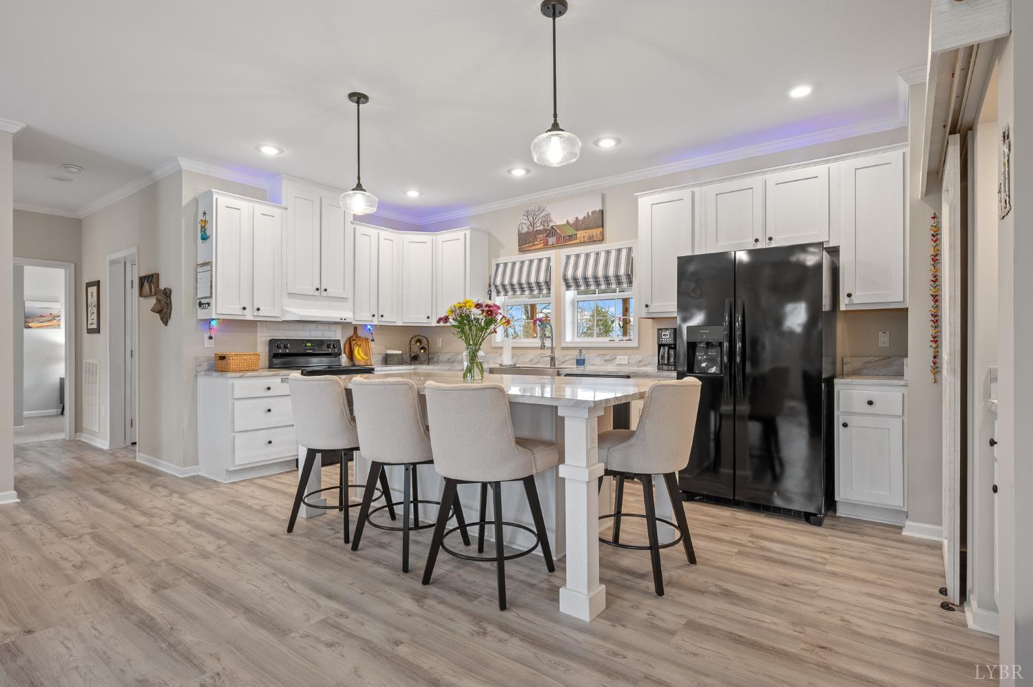 5049 Horseshoe Bend Road Goodview, VA 24095 - Photo 18 of 43 a kitchen with stainless steel appliances kitchen island granite countertop a refrigerator a stove a microwave oven a dining table and chairs with wooden floor