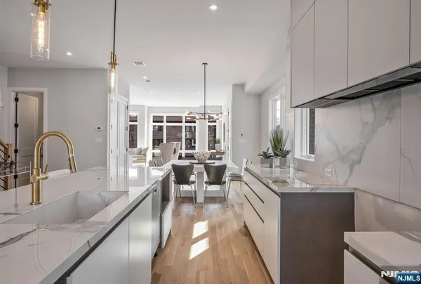 a large kitchen with kitchen island a large counter top space a sink stainless steel appliances and cabinets