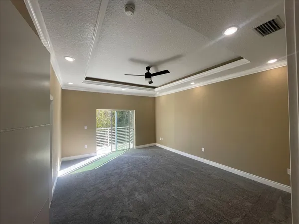 an empty room with windows and a ceiling fan