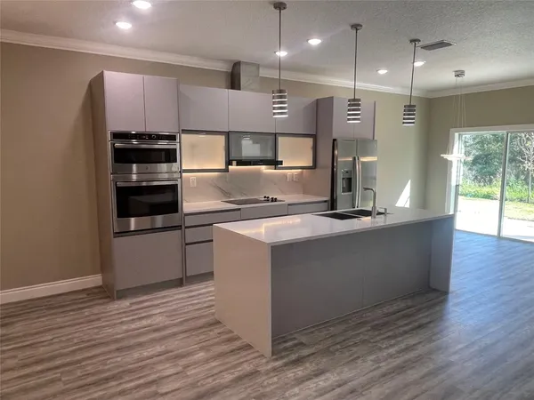 a kitchen with kitchen island a counter top space a stove and cabinets