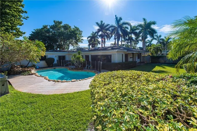 a view of a house with a small yard and potted plants
