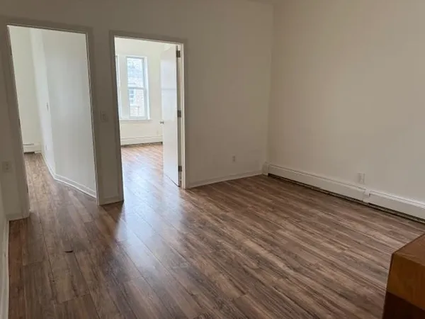a view of a room with wooden floor and white walls