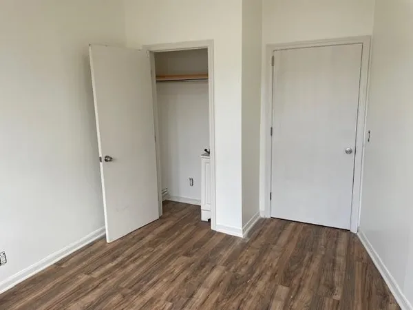 an empty room with wooden floor and closet