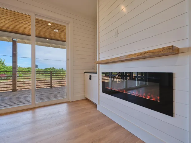 a view of empty room with wooden floor and fireplace