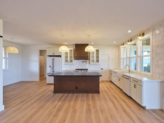 a large kitchen with kitchen island a sink stainless steel appliances and cabinets