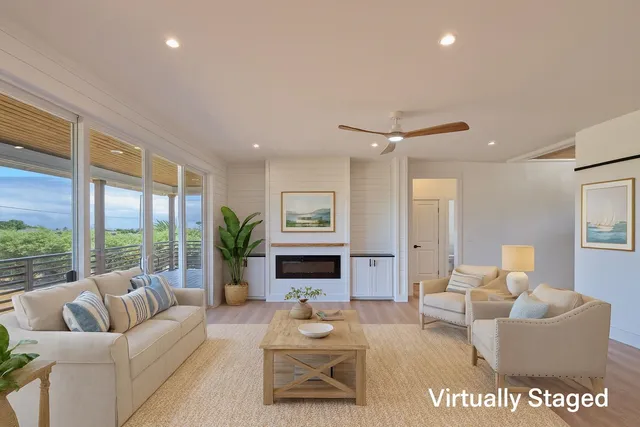 a living room with furniture large window and a fireplace