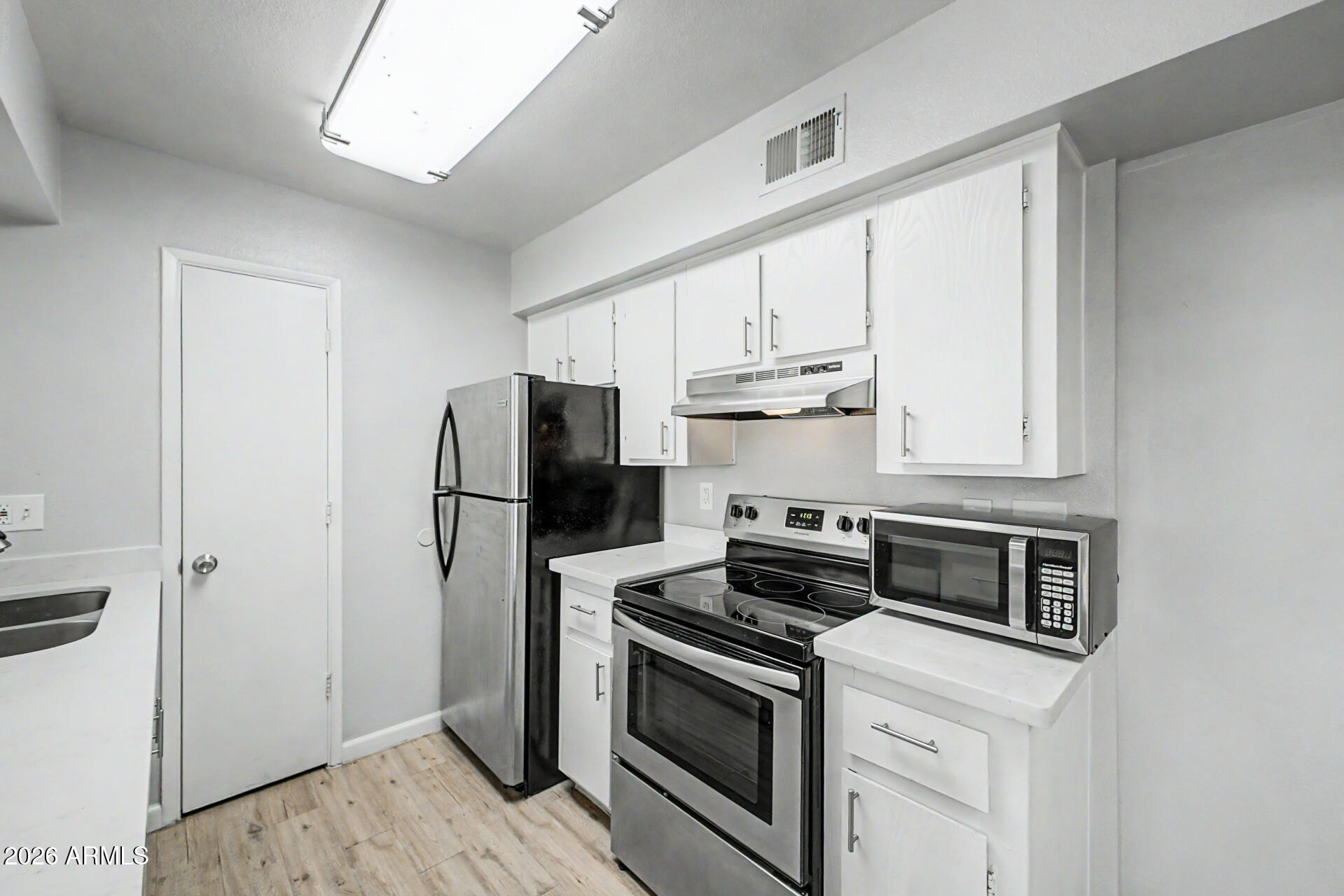 2625 East Indian School Road, Unit 227 Phoenix, AZ 85016 - Photo 2 of 31 a kitchen with stainless steel appliances a stove microwave and refrigerator