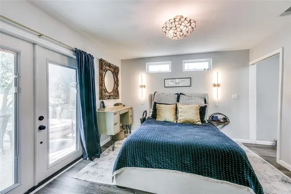 a spacious bedroom with a bed and a chandelier