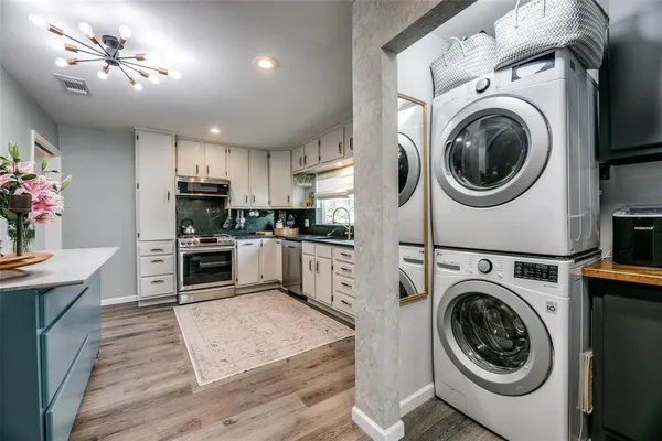 a kitchen with stainless steel appliances kitchen island granite countertop a sink a stove top oven and cabinets