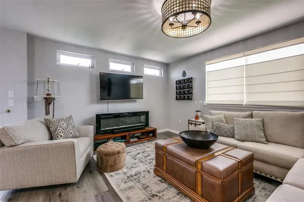 a living room with furniture a flat screen tv and a window