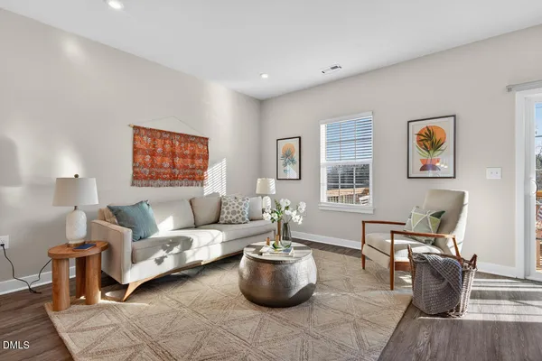 a living room with furniture a flat screen tv and a large window