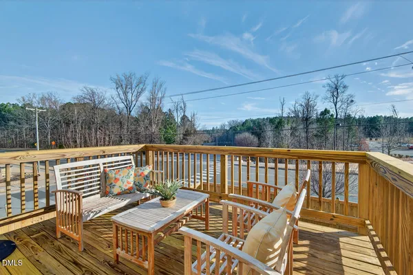 a living room with furniture kitchen view and a wooden floor