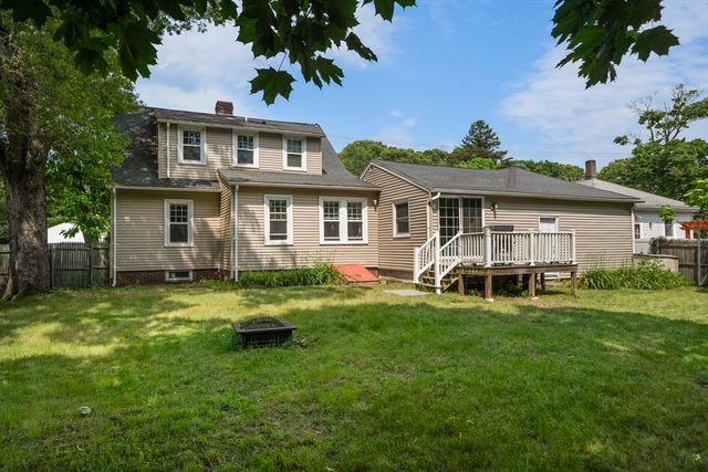 a view of a house with a yard and sitting area