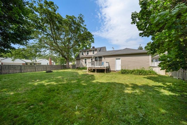 a front view of a house with a yard and trees
