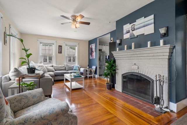 a living room with furniture a large window and a fireplace