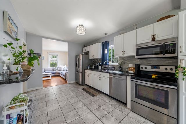 a kitchen with stainless steel appliances kitchen island granite countertop a stove a sink and a microwave