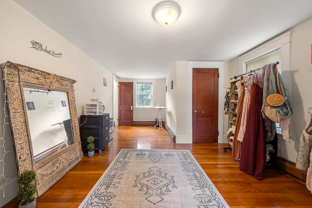 a view of a hallway with furniture and wooden floor