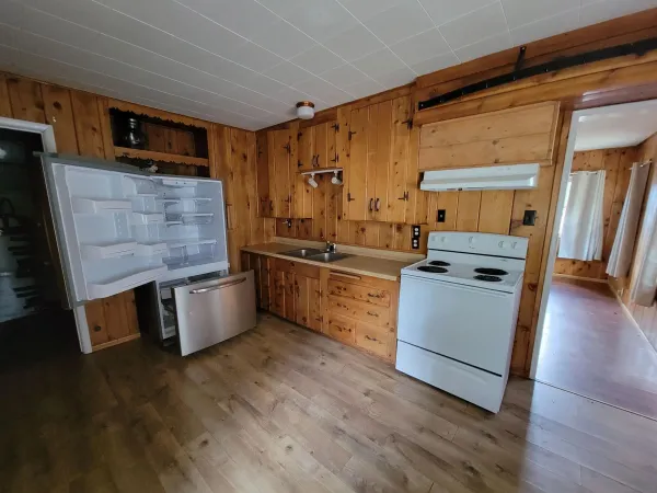 a kitchen with stainless steel appliances a stove top oven a sink and a refrigerator