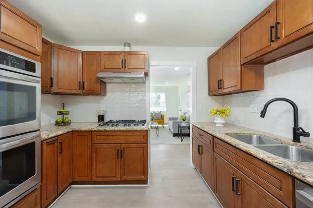 a kitchen with stainless steel appliances granite countertop a sink stove and cabinets