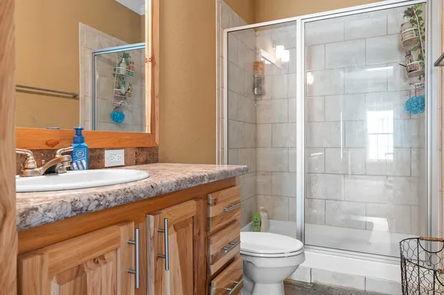 a bathroom with a granite countertop sink toilet and shower