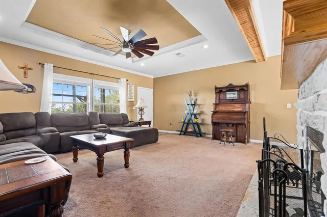 a living room with furniture a fireplace and a large window