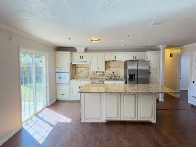 a kitchen with stainless steel appliances a sink cabinets and wooden floor