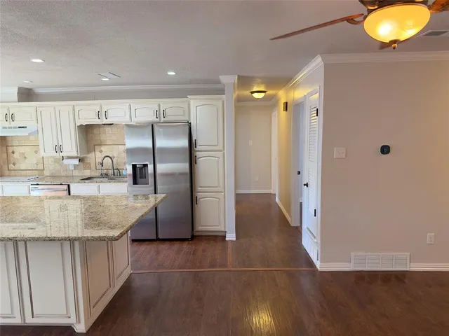 a kitchen with kitchen island a counter top space a sink and refrigerator