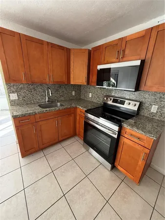 a kitchen with stainless steel appliances stove top oven and cabinets