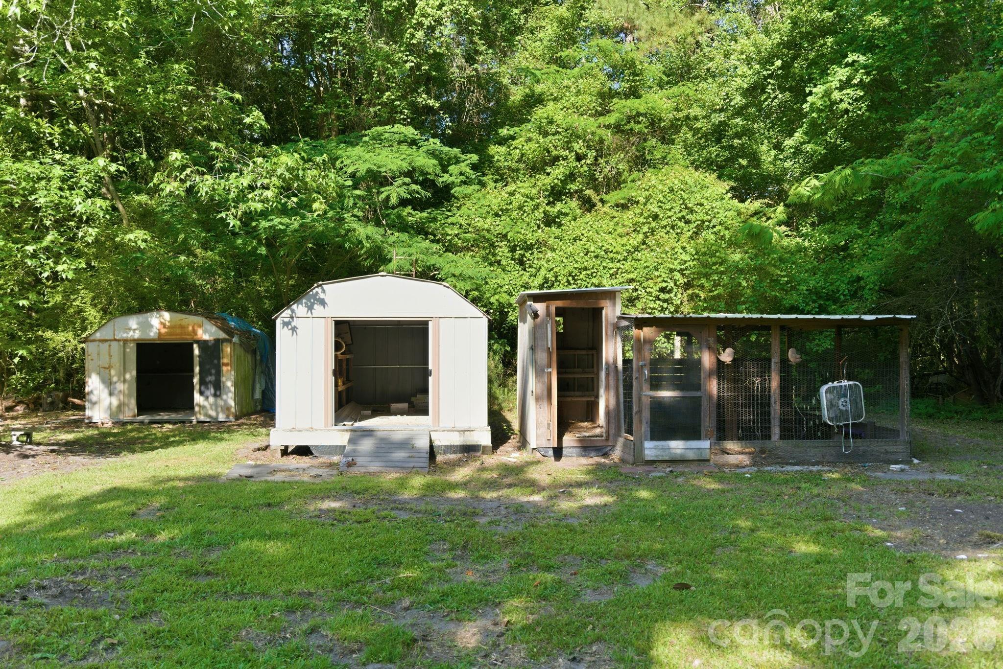 481 Harrell Road Burgaw, NC 28425 - Photo 21 of 25 a view of a backyard with table and chairs and potted plants with large trees