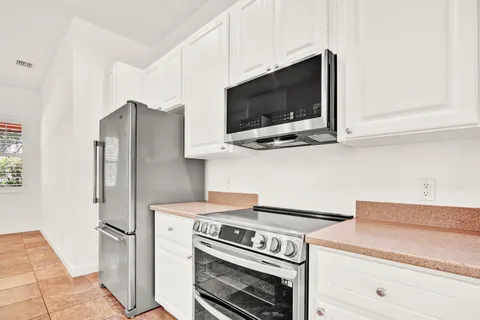 a kitchen with stainless steel appliances white cabinets and a stove