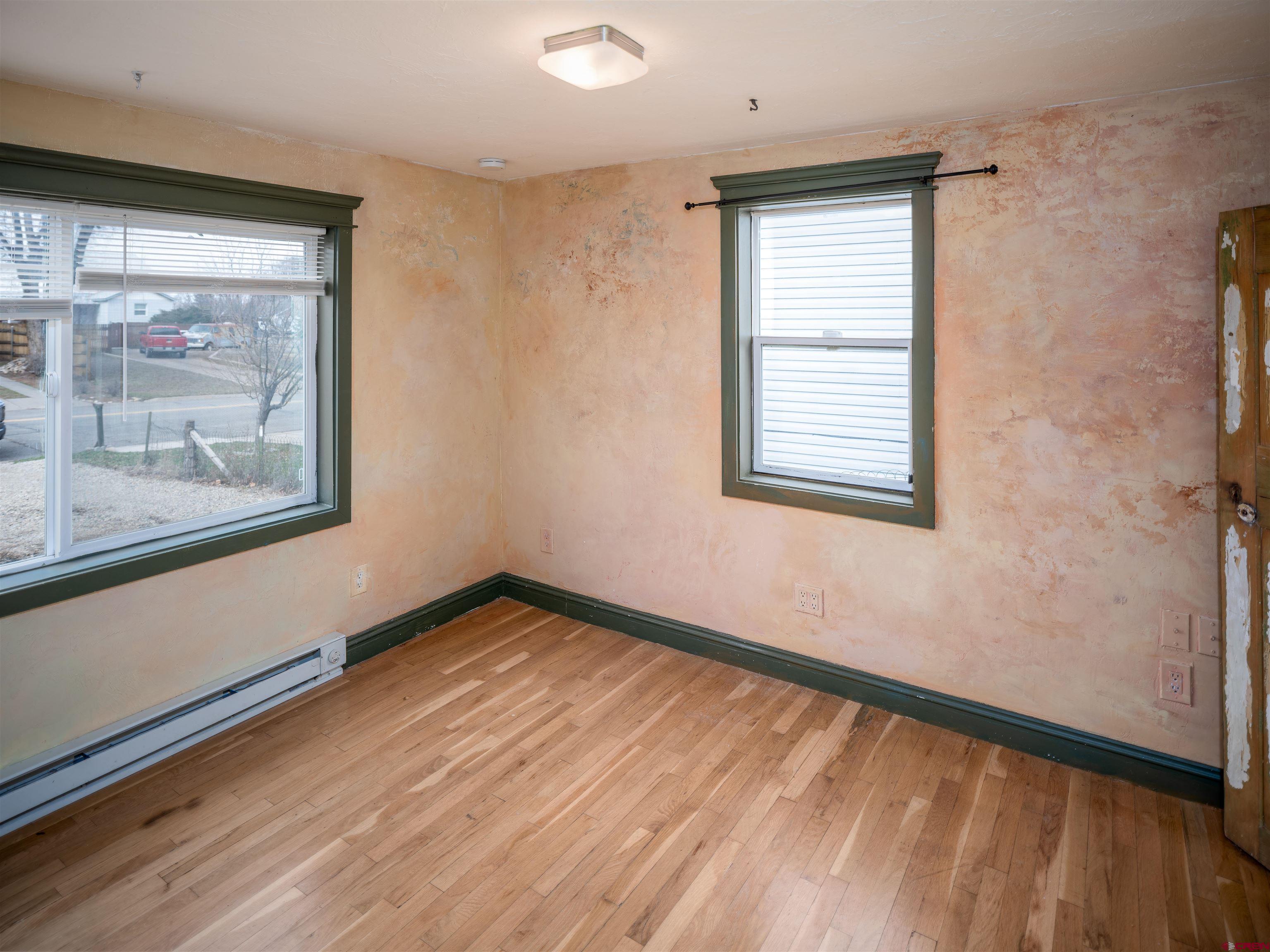 312 North Beech Street Cortez, CO 81321 - Photo 14 of 37 a view of an empty room with wooden floor and a window