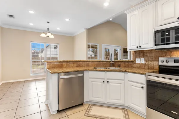 a kitchen with stainless steel appliances granite countertop a sink and a stove