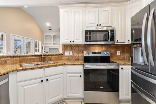 a kitchen with stainless steel appliances granite countertop a stove microwave and refrigerator