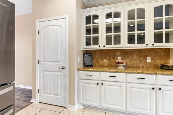a view of white kitchen with granite countertop cabinets and outdoor space